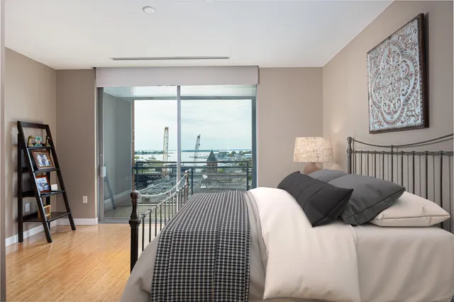 a bedroom with a bed a couch and a large window