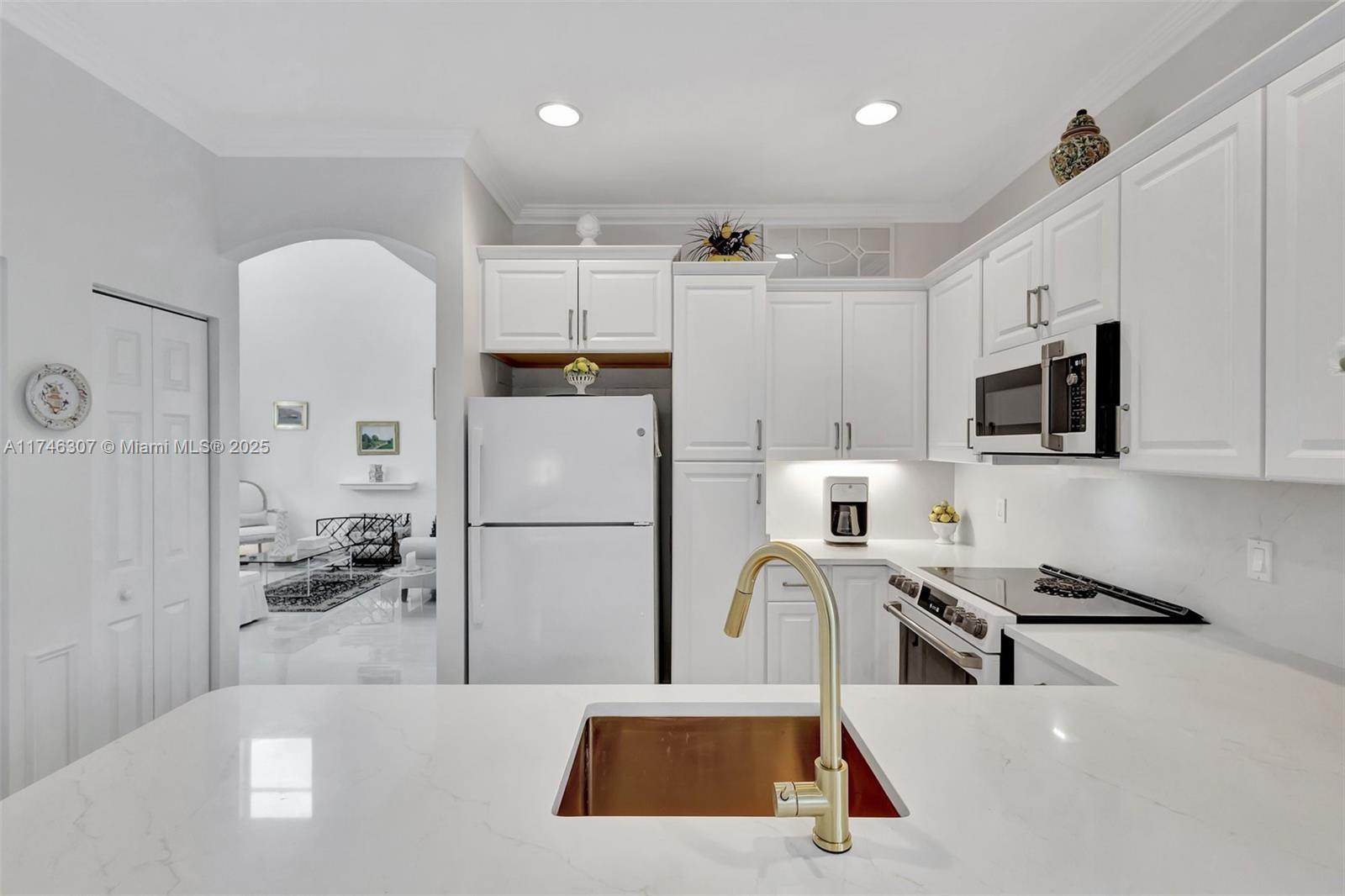 1826 Capeside Circle Wellington, FL 33414 - Photo 33 of 73 a kitchen with a refrigerator a stove top oven a sink a dining table and chairs