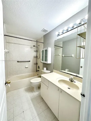 a bathroom with a granite countertop sink toilet mirror and shower