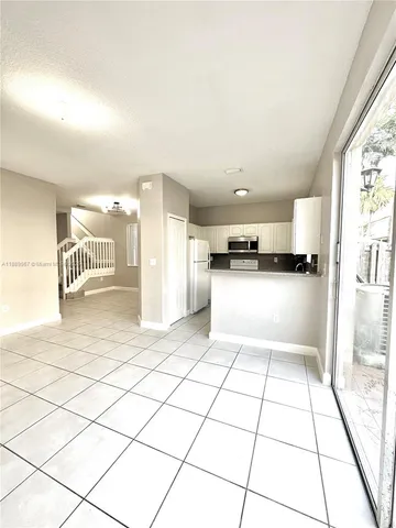 a view of kitchen with furniture and refrigerator