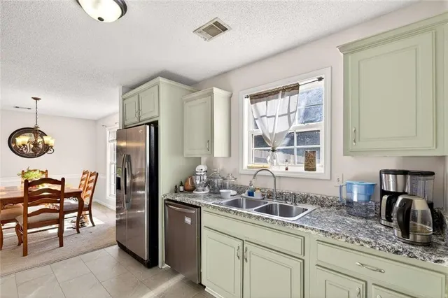 a kitchen with stainless steel appliances granite countertop a sink and a refrigerator