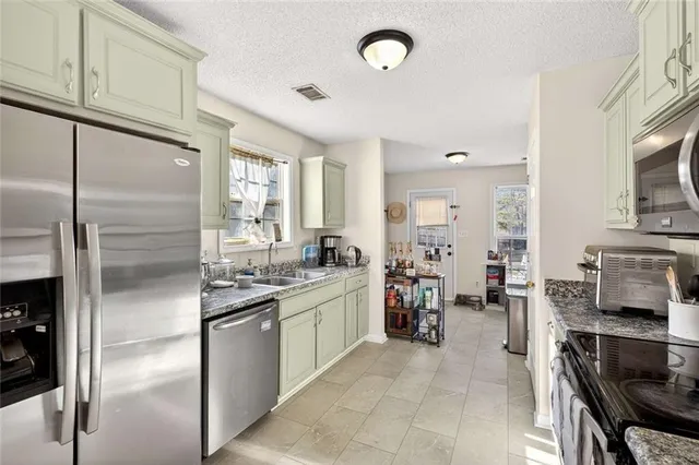 a kitchen with stainless steel appliances granite countertop a refrigerator and a stove top oven