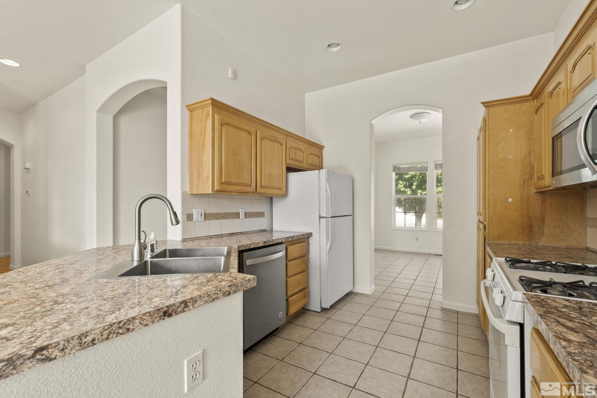 1442 Wessex Circle Reno, NV 89503 - Photo 11 of 32 a kitchen with granite countertop a stove a sink and a microwave