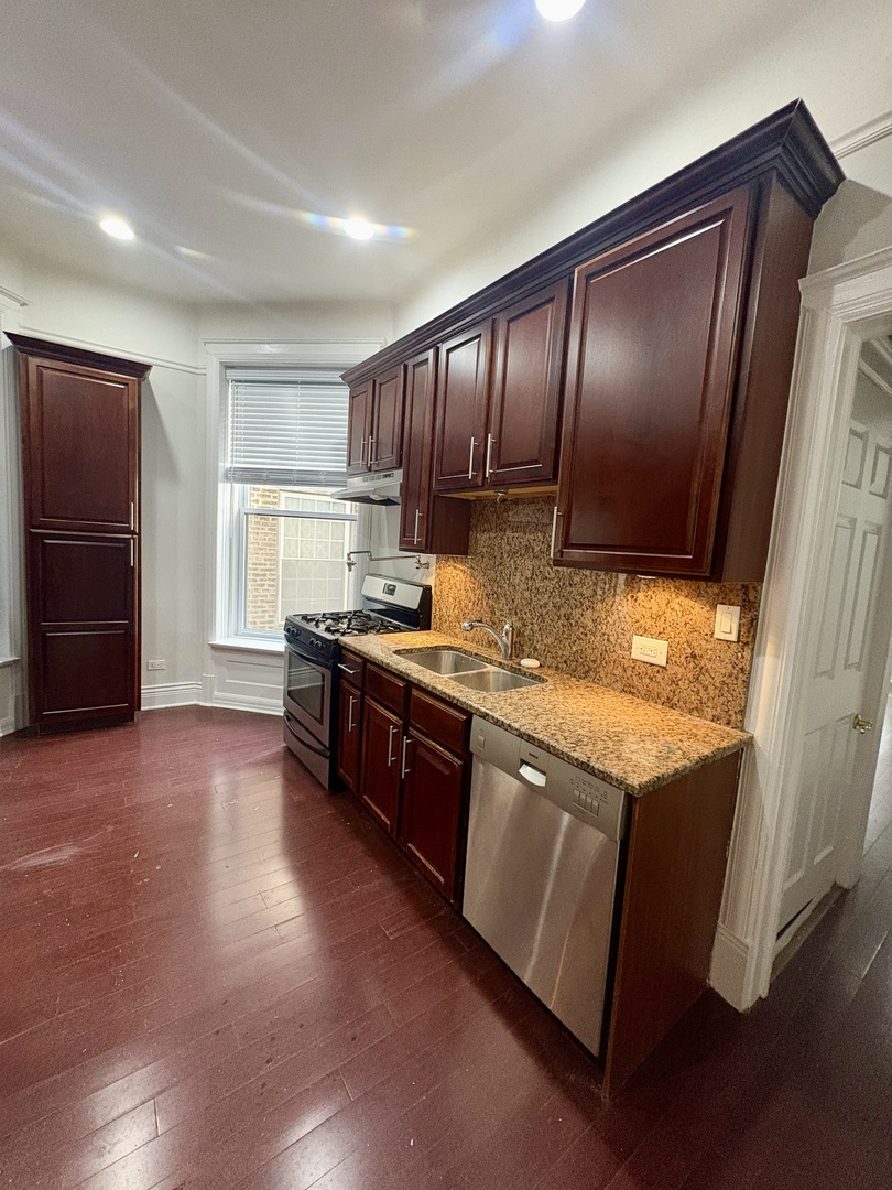 12 West Chestnut Street, Unit 3 Chicago, IL 60610 - Photo 16 of 20 a kitchen with granite countertop wooden cabinets and a stove