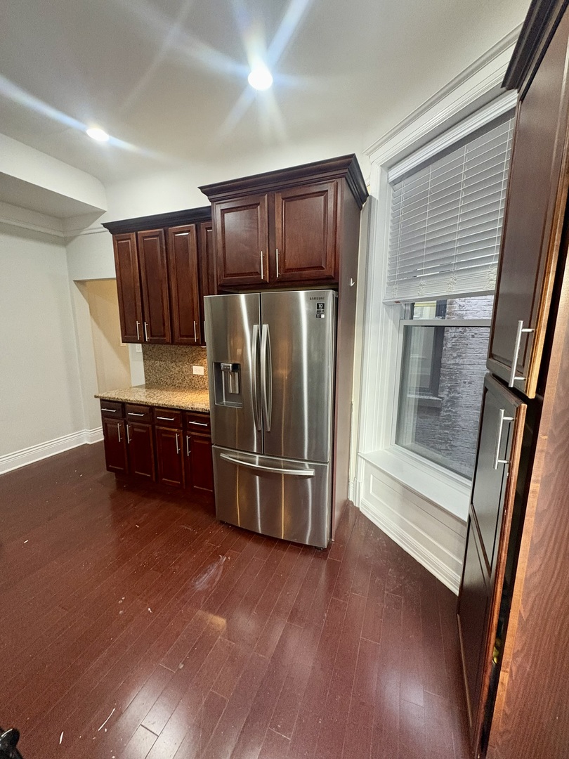 12 West Chestnut Street, Unit 3 Chicago, IL 60610 - Photo 17 of 20 a kitchen with stainless steel appliances wooden cabinets and a refrigerator