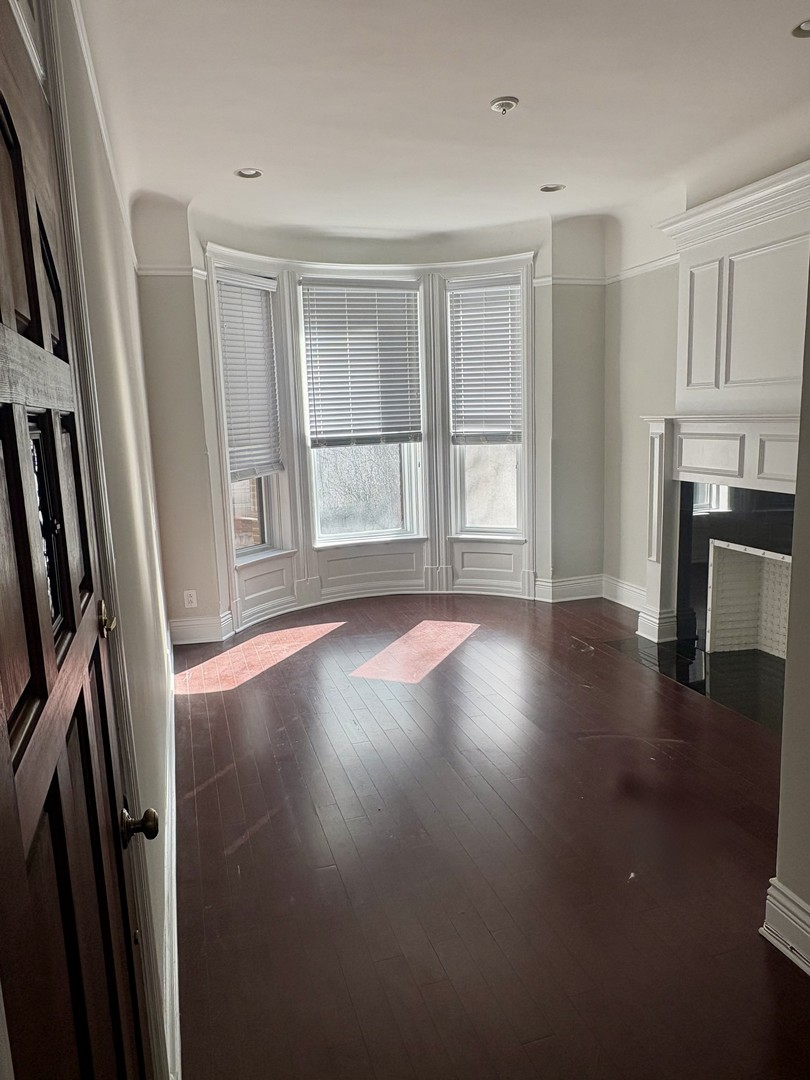12 West Chestnut Street, Unit 3 Chicago, IL 60610 - Photo 3 of 20 an empty room with wooden floor and a window