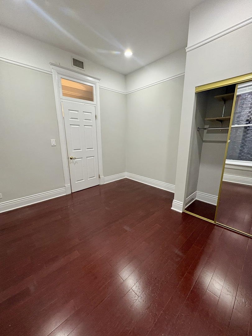 12 West Chestnut Street, Unit 3 Chicago, IL 60610 - Photo 4 of 20 an empty room with wooden floor door and windows