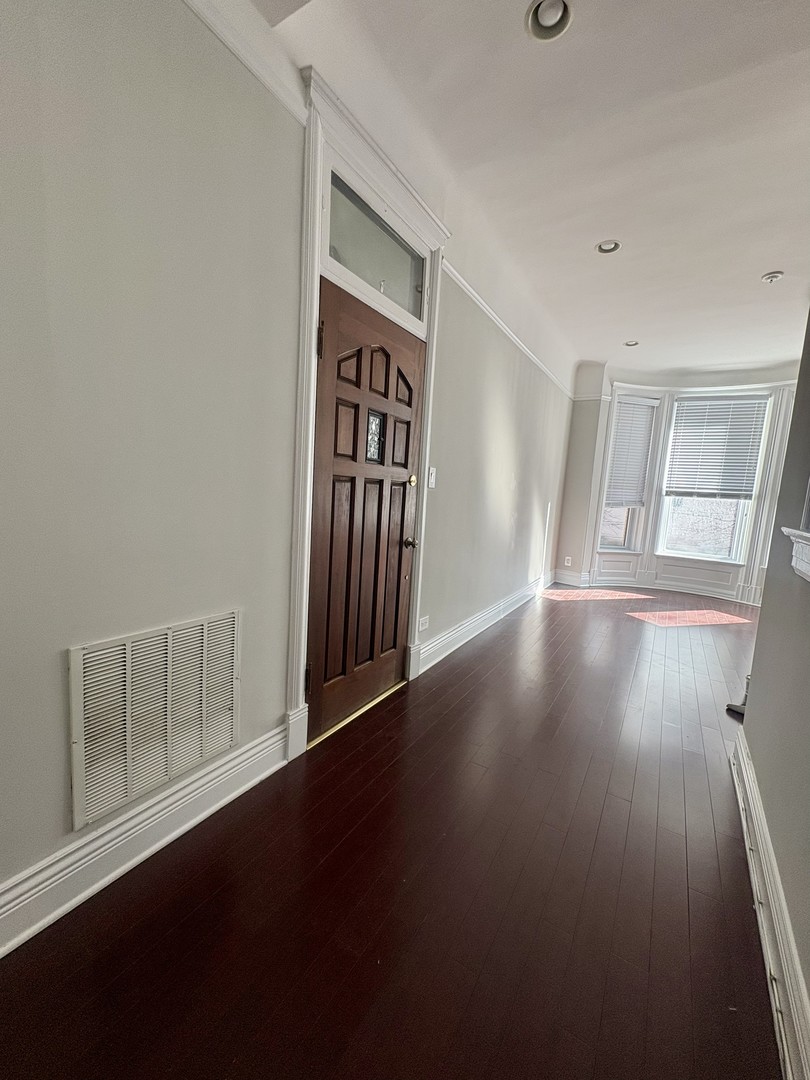 12 West Chestnut Street, Unit 3 Chicago, IL 60610 - Photo 5 of 20 an empty room with wooden floor and windows