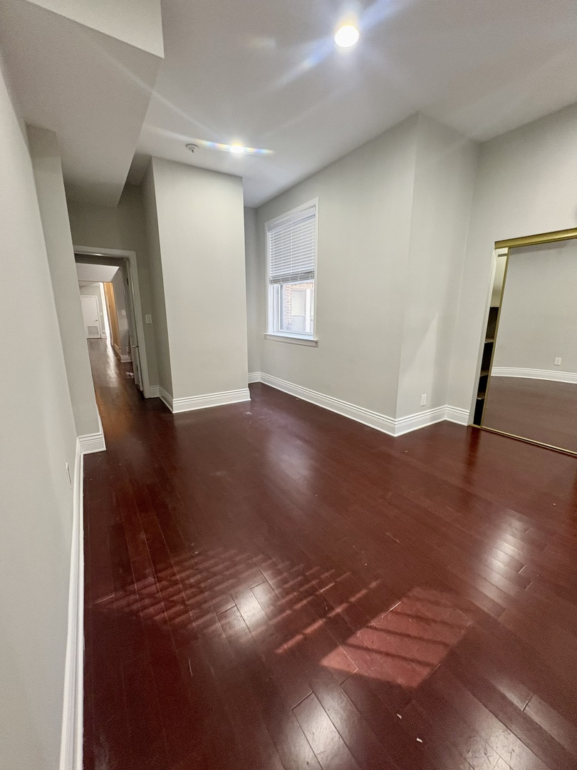 12 West Chestnut Street, Unit 3 Chicago, IL 60610 - Photo 8 of 20 a view of an empty room with wooden floor and a window
