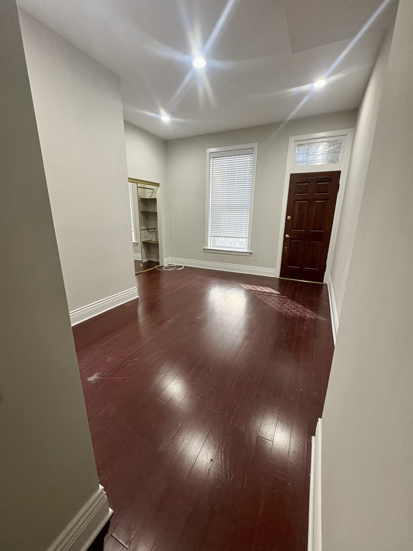 12 West Chestnut Street, Unit 3 Chicago, IL 60610 - Photo 9 of 20 an empty room with wooden floor and windows