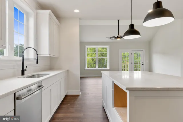 a view of a kitchen with wooden floor and a kitchen space with a sink