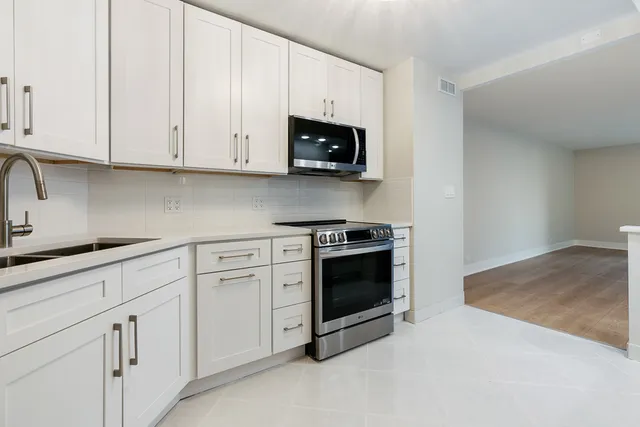 a kitchen with white cabinets and stainless steel appliances