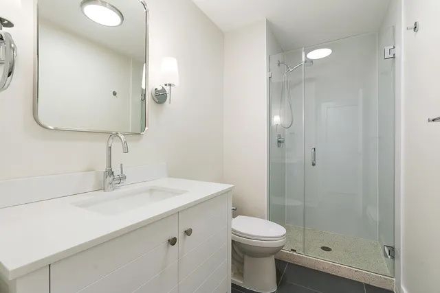 a bathroom with a sink a toilet and shower