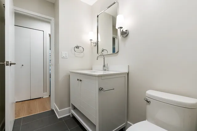 a bathroom with a sink a toilet and a mirror