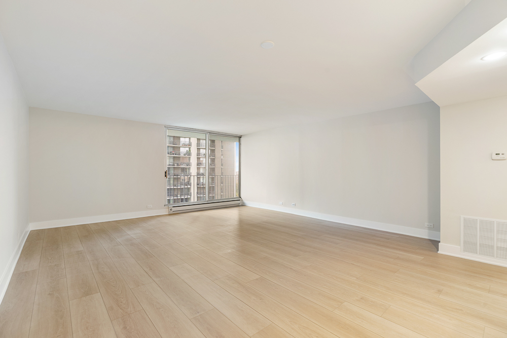 6033 North Sheridan Road, Unit 8E Chicago, IL 60660 - Photo 6 of 31 a view of an empty room with wooden floor and window