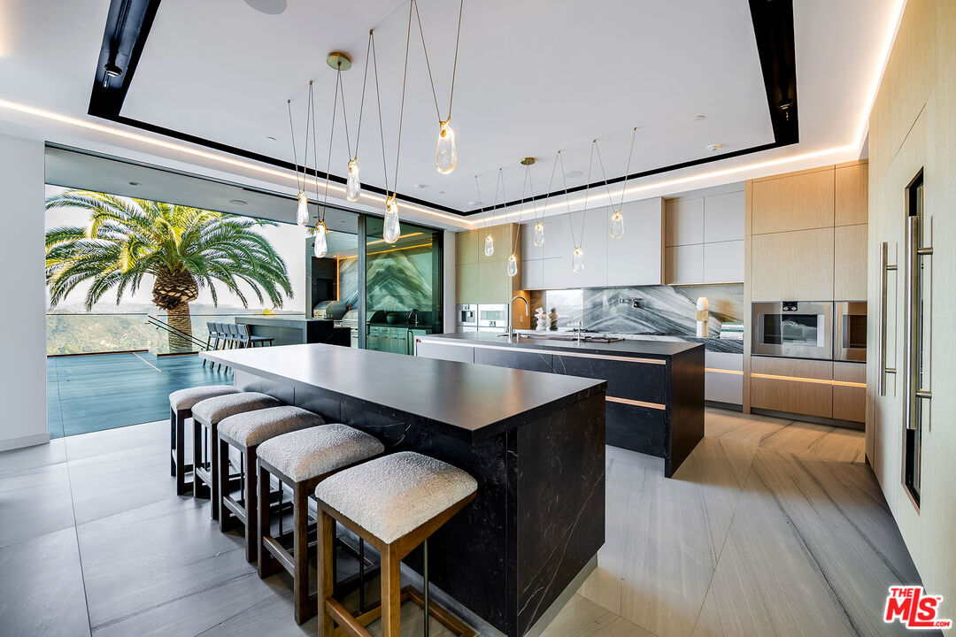 2078 Stradella Road Los Angeles, CA 90077 - Photo 11 of 37 a kitchen with a table chairs sink and cabinets