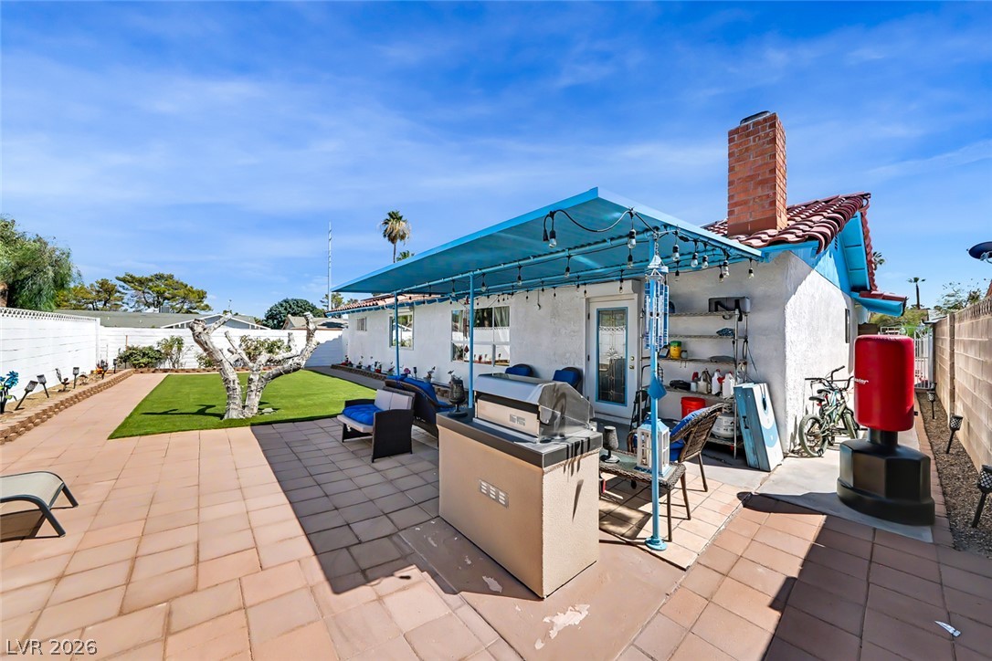 3107 Trueno Road Henderson, NV 89014 - Photo 34 of 37 A private yard with artificial turf and a covered patio offers ample space for outdoor living.