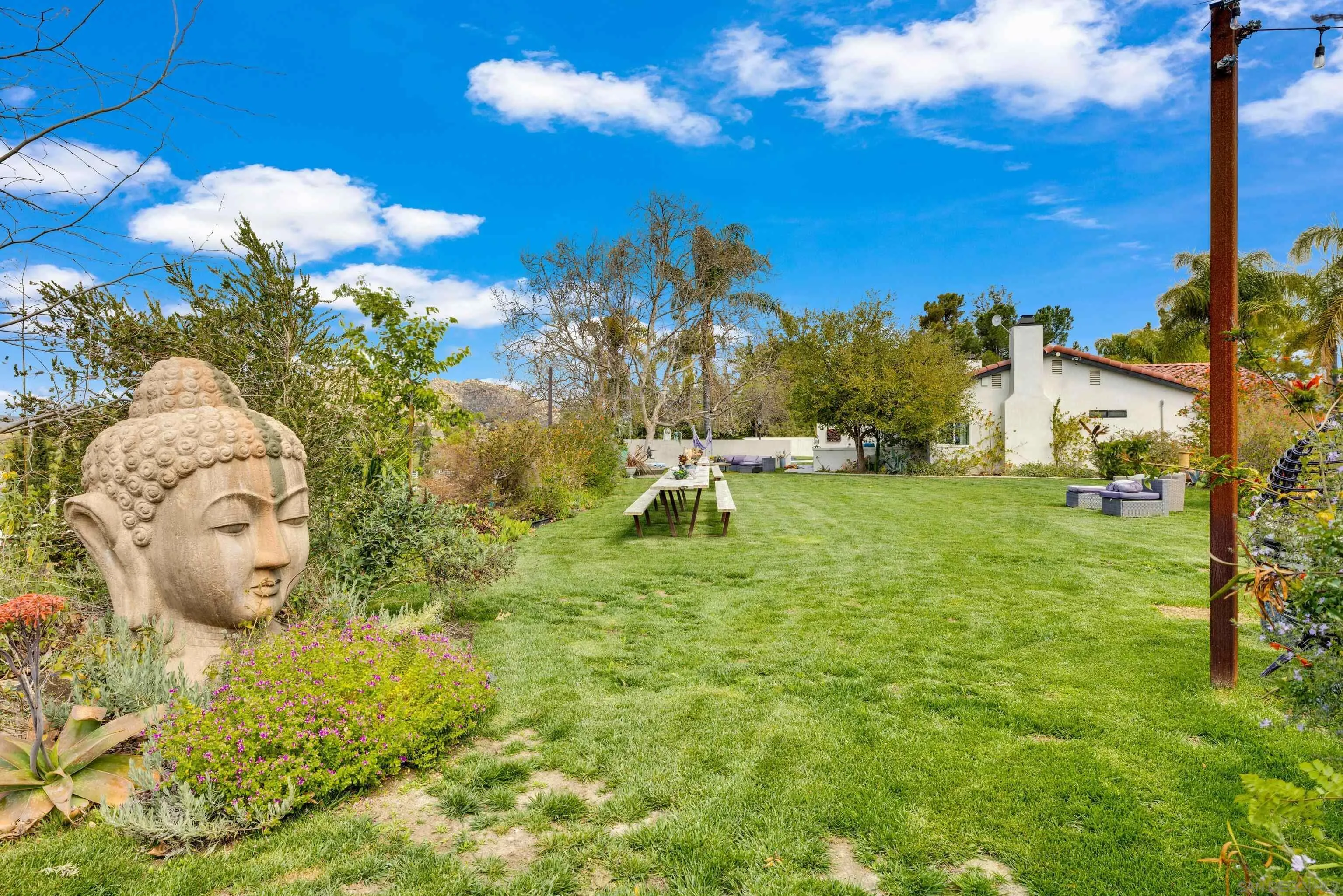 37389 Ave Chapala Temecula, CA 92592 - Photo 37 of 68 a backyard of a house with table and chairs plants and large trees
