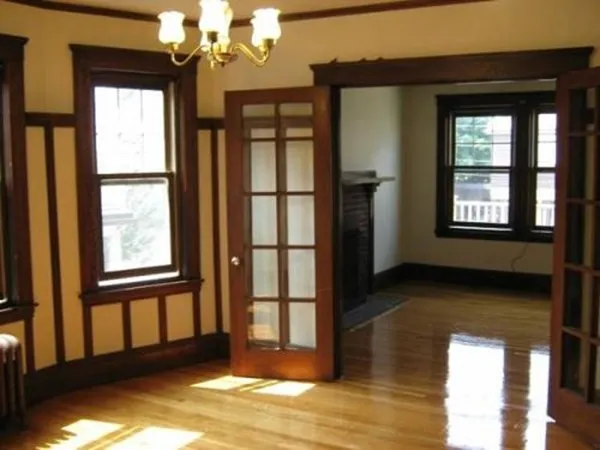 a view of an empty room with a window and wooden floor
