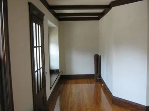 a view of a hallway with wooden floor and staircase