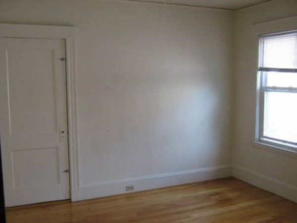 28 Commonwealth Road, Unit 2 Watertown, MA 02472 - Photo 9 of 10 an empty room with wooden floor and windows