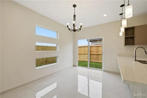 a living room with stainless steel appliances granite countertop furniture and a chandelier
