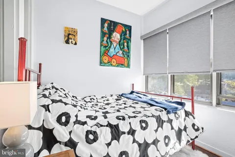 a bedroom with wooden floor and wall painting