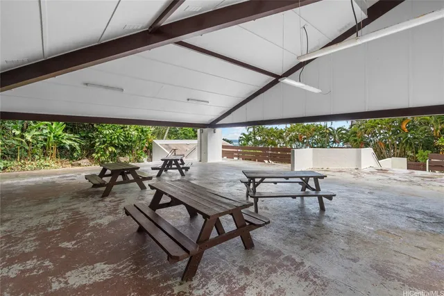 a view of a patio with table and chairs under an umbrella