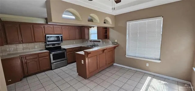 a kitchen with stainless steel appliances granite countertop a stove a sink and a microwave