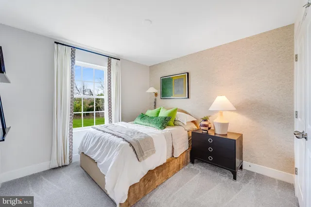 a bedroom with a bed lamp and a large window