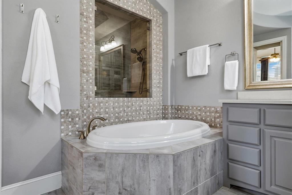 1933 Snapdragon Road Frisco, TX 75033 - Photo 21 of 40 Soaking tub with bronze finish fixtures, integrated into a tiled surround with mosaic accents