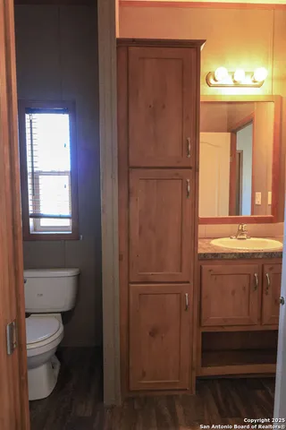 a bathroom with a toilet a sink and a window