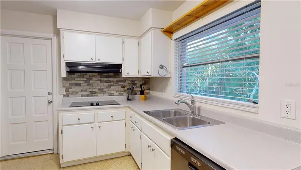 a kitchen with stainless steel appliances white cabinets and a refrigerator
