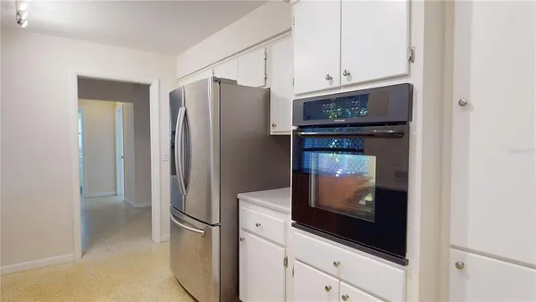 an empty room with chandelier fan and windows