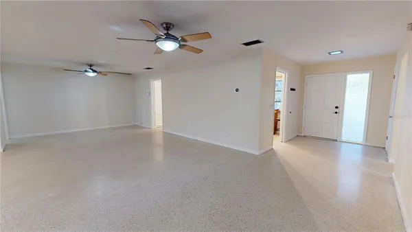 an empty room with windows and fan