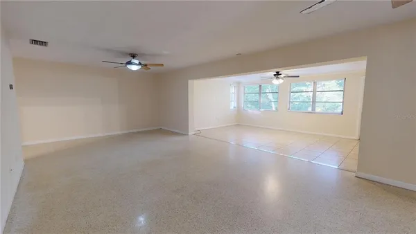 an empty room with fan and windows