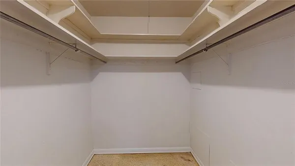 a view of backyard of house with wooden fence and potted plants