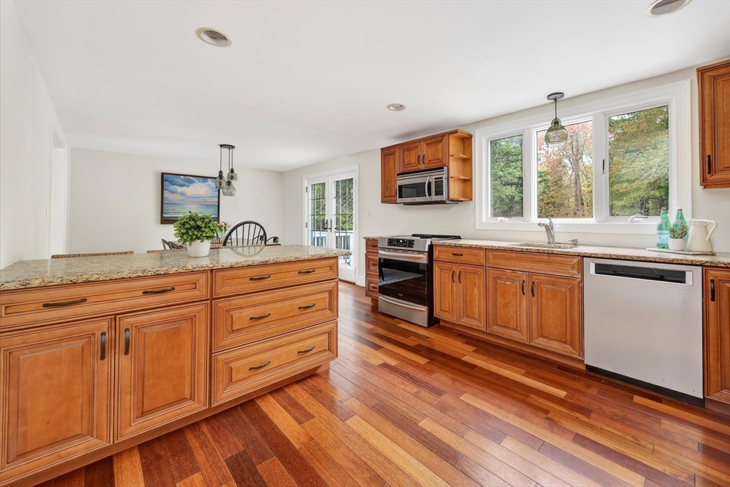 59 First Parish Road Norwell, MA 02061 - Photo 11 of 37 a kitchen with stainless steel appliances granite countertop a stove a sink and white cabinets with wooden floor next to windows