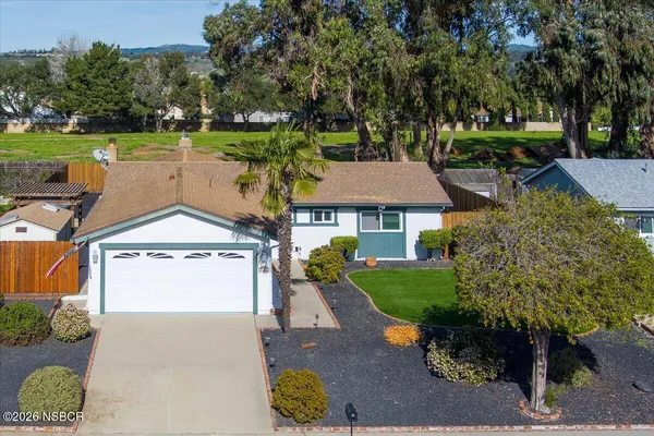 an aerial view of a house with garden space and a patio