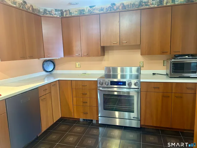 a kitchen with stainless steel appliances granite countertop a sink window and cabinets
