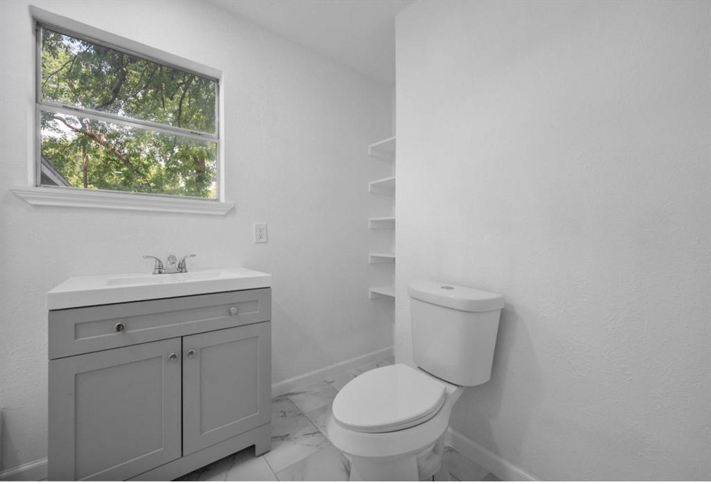 200 Austin Street Rice, TX 75155 - Photo 11 of 22 a bathroom with a toilet a sink a window and mirror