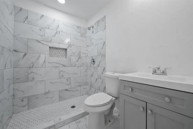 a bathroom with a sink a toilet and shower