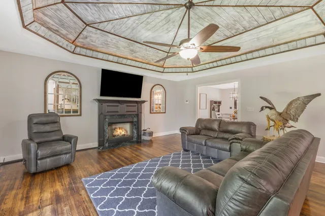 a bedroom with a bed a desk and chair with wooden floor