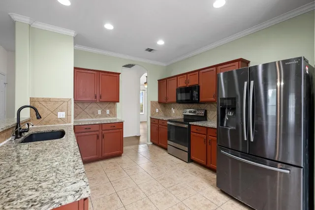 a kitchen with stainless steel appliances granite countertop a refrigerator sink and stove