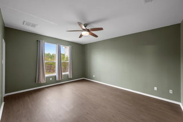 a view of room with window ceiling fan and hardwood floor