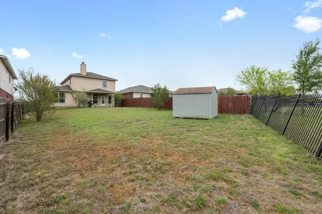a view of a house with backyard and a tree