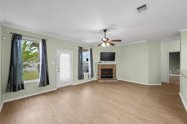 a view of an empty room with a fireplace and a window