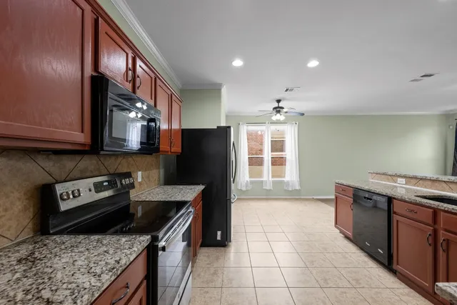 a kitchen with stainless steel appliances granite countertop a stove a sink and a microwave