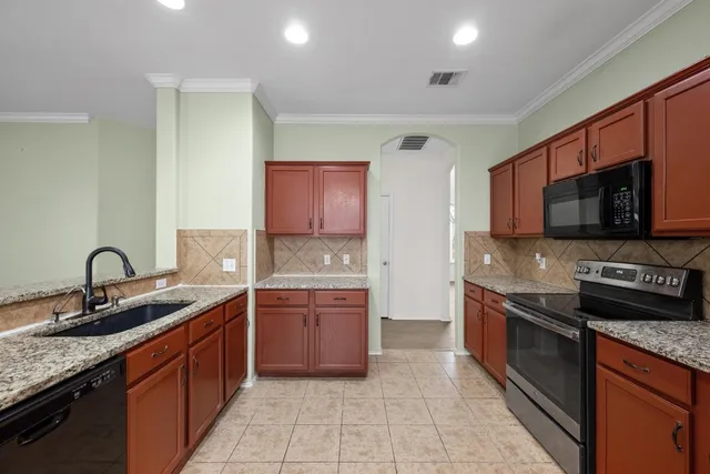 a kitchen with stainless steel appliances granite countertop a sink and dishwasher a stove top oven with wooden floor