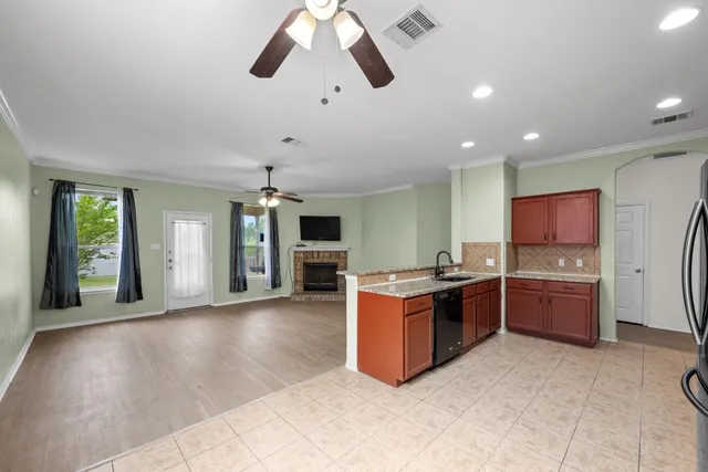 a large kitchen with stainless steel appliances granite countertop a stove and a sink with cabinets